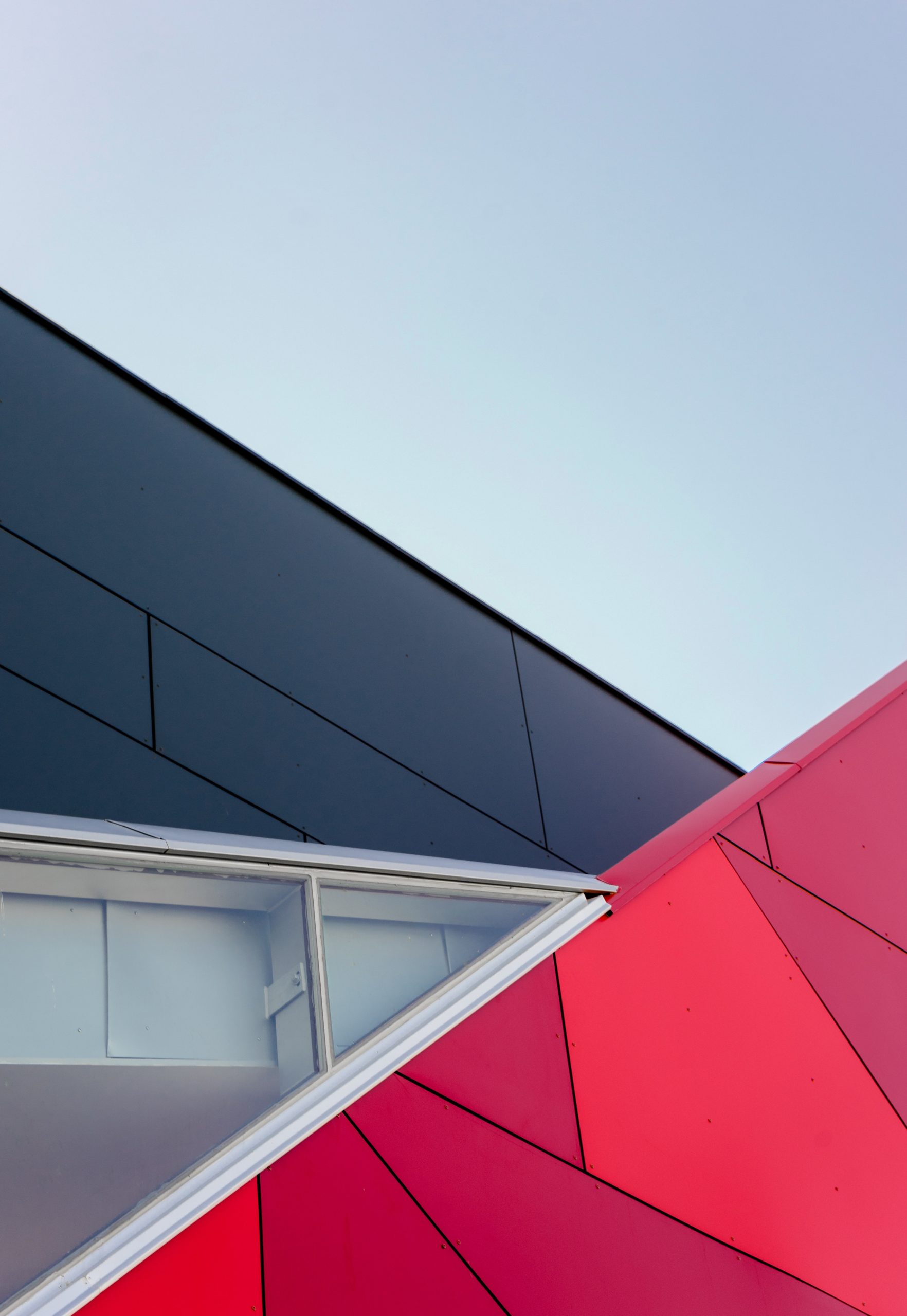 Geometryczny detal architektoniczny w czerni, czerwieni i bieli.